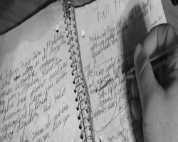 Picture of someone writing in a notebook